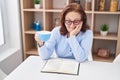 Senior woman drinking coffee reading book at home Royalty Free Stock Photo