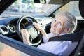 Senior woman driving car on sunny day