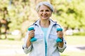 Senior woman with dumbbells exercising at park Royalty Free Stock Photo