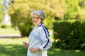 Senior woman with earphones running in summer park Royalty Free Stock Photo