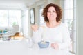 Senior woman eating asian noodles using chopsticks with a confident expression on smart face thinking serious Royalty Free Stock Photo