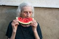 Senior woman eating watermelon outdoors