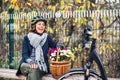 A senior woman with electrobike and flowers sitting on a bench outdoors in town. Royalty Free Stock Photo