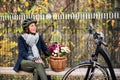 A senior woman with electrobike and flowers sitting on a bench outdoors in town. Royalty Free Stock Photo