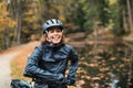 A senior woman with electrobike standing outdoors on a road in park in autumn. Royalty Free Stock Photo