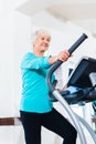 Senior woman on elliptical trainer exercising Royalty Free Stock Photo