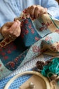 Close Up Of Senior Woman Embroidering Cushion Cover At Home