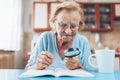 Senior woman enjoys solving a crossword puzzle Royalty Free Stock Photo