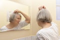 Senior woman examining hair loss