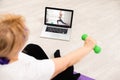 Senior woman exercise using laptop online instructions at home health care