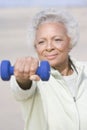 Senior Woman Exercising With Dumbbells At Beach Royalty Free Stock Photo