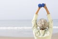 Senior Woman Exercising With Dumbbells On Beach Royalty Free Stock Photo