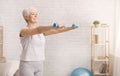 Senior woman exercising with dumbbells at home Royalty Free Stock Photo