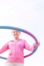 Senior woman exercising with hula hoop against sky Royalty Free Stock Photo