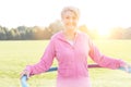 Senior woman exercising with hula hoop in park Royalty Free Stock Photo