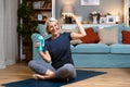 Senior woman exercising while sitting in lotus position. Active mature woman doing stretching exercise in living room at home. Fit Royalty Free Stock Photo