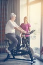 Senior woman exercising on stationary bikes in fitness class. Royalty Free Stock Photo