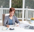 Senior woman having stress looking at her calculator while working on bills