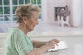 Senior woman with eyeglasses browsing on digital tablet