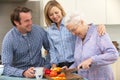 Senior woman and family preparing meal together Royalty Free Stock Photo