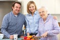 Senior woman and family preparing meal together Royalty Free Stock Photo