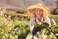 Senior woman farmer with fresh leafy vegetables outdoors