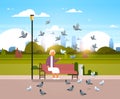 Senior woman feeding flock of pigeon sitting wooden bench urban city park cityscape background horizontal flat