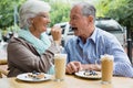 Senior woman feeding tart to man in cafÃÂ© Royalty Free Stock Photo