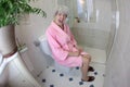 Senior woman feeling constipated in the bathroom