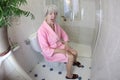 Senior woman feeling constipated in the bathroom