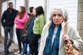 Senior Woman Feeling Intimidated By Group Of Young People