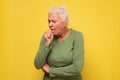 Senior woman feeling unwell and coughing as symptom for cold or bronchitis