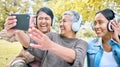 Senior woman, friends and phone laughing with headphones listening to music or watching comedy movie in the park. Group Royalty Free Stock Photo