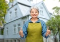 senior woman in garden apron showing thumbs up