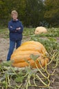 Senior Woman in Garden Growing Giant Pumpkin