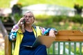 Middle age woman at the garden working from home using laptop and speaking on the phone Royalty Free Stock Photo