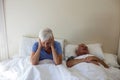 Senior woman getting disturbed with man snoring on bed Royalty Free Stock Photo