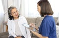 A senior woman giving a health interview to a home visiting nurse at home Royalty Free Stock Photo