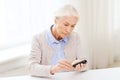 Senior woman with glucometer checking blood sugar