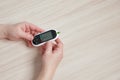 Senior woman with glucometer and test stripe checking blood sugar level at home Royalty Free Stock Photo