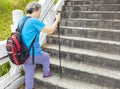 Senior woman goes up the stairs