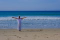 Senior woman with gray hair doing qi gong and yoga on the beach of Tarifa Royalty Free Stock Photo