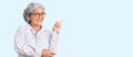 Senior woman with gray hair wearing casual business clothes and glasses smiling happy pointing with hand and finger to the side Royalty Free Stock Photo