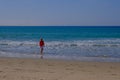 Senior woman with gray har walking in the water on the beach og Tarifa