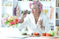 Senior woman in hair rollers singing karaoke with laptop at home Royalty Free Stock Photo