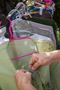 Senior woman hands dry green clothes in the sun with Colourful plastic clothes hang on stainless steel clothes rack