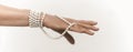 Senior woman hand with Pearl necklace cut out on white. Luxury jewelry on female hand with French manicure. Close up