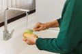 Senior woman hand washing dirt off homegrown potatoes with a brush. Royalty Free Stock Photo