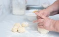 Senior woman hands kneading dough on a white kitchen table with blurred grated apple and sugar on background. Selective Royalty Free Stock Photo