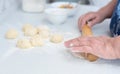 Senior woman hands rolling out the dough with a rolling pin on a white kitchen table with blurred grated apple and sugar Royalty Free Stock Photo